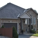 large suburban house will newly-installed shingle roof, installed by Baron Roofing & Siding